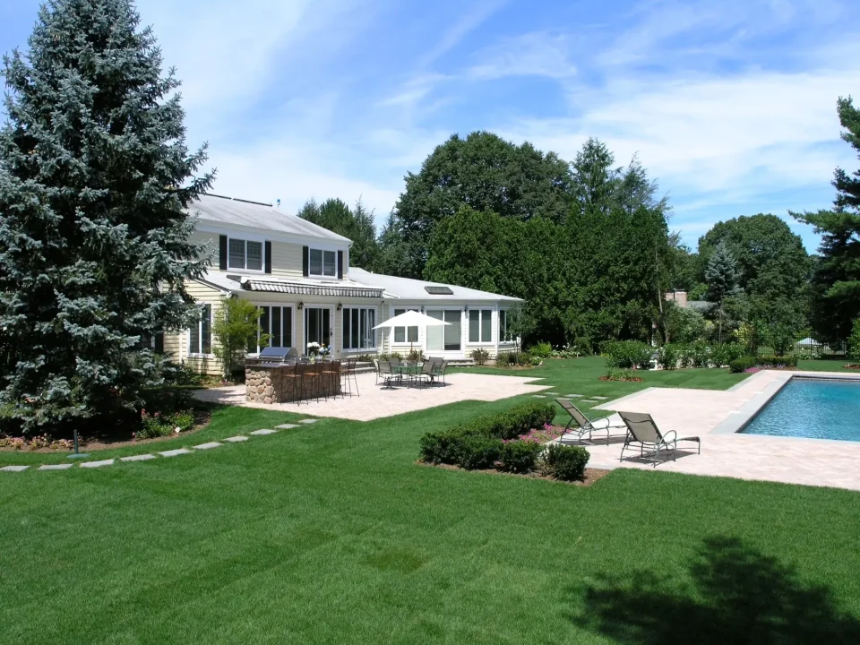 Suburban house with pool, patio, and landscaped garden.