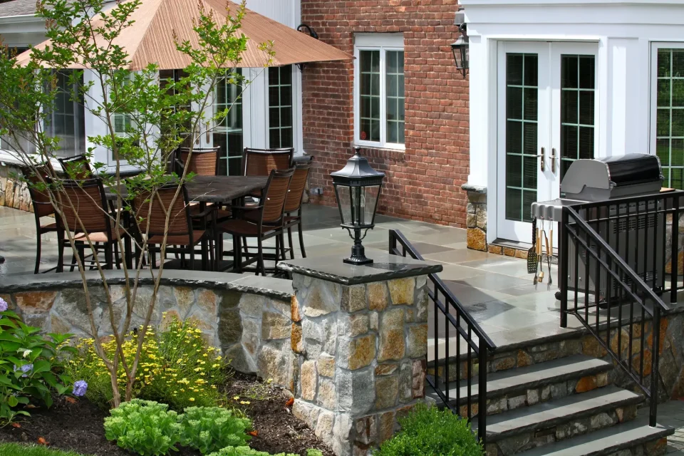 Elegant stone patio with seating and landscaped garden.
