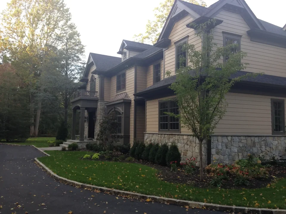 A large two-story house with stone accents and a landscaped front yard.