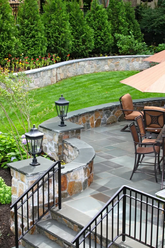 Elegant stone patio with seating and landscaped garden.