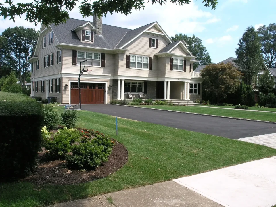 beautifully landscaped front yard with basketball hoop in driveway